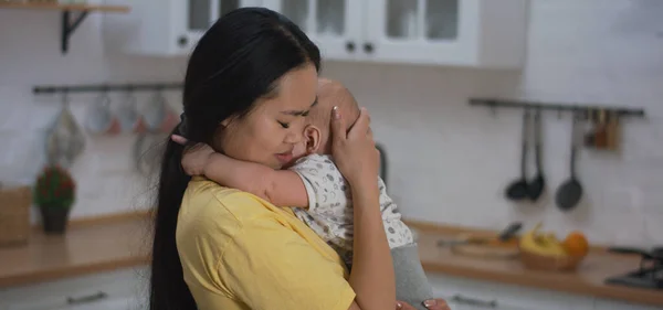 Mãe segurando choro bebê nos braços — Fotografia de Stock