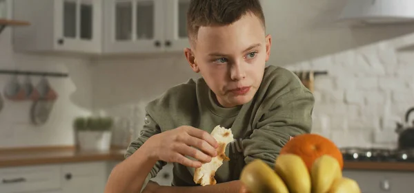 Menino comendo na cozinha sozinho — Fotografia de Stock