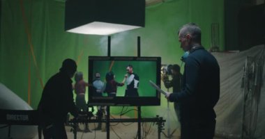 Cosmetician preparing an actor while others discussing the scene