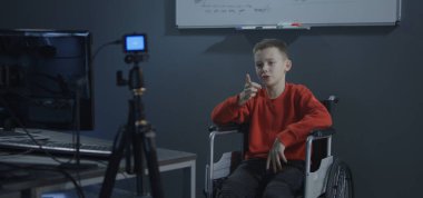 Boy in wheelchair recording a video for vlog