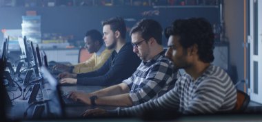 Programmers working and one turning to the camera
