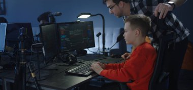 Child programmer getting instructions from colleague