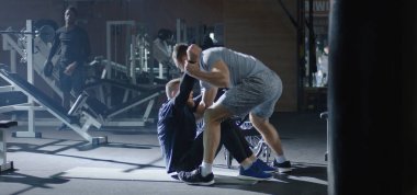 Trainer lifting disabled man into wheelchair
