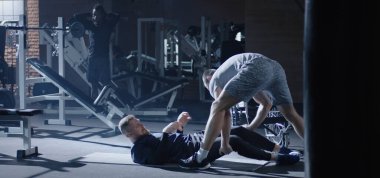 Trainer lifting disabled man into wheelchair