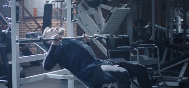 Disabled man shoving away wheelchair angrily