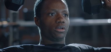 Young man lifting weight in gym