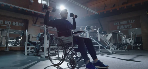 Silla de ruedas hombre levantamiento de peso en gimnasio —  Fotos de Stock