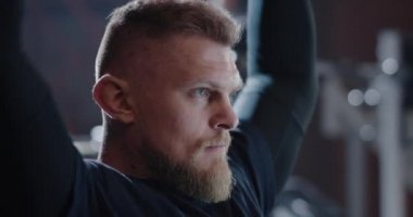Young man lifting weight in gym