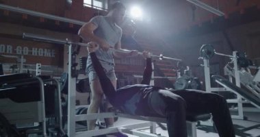 Trainer lifting disabled man into wheelchair