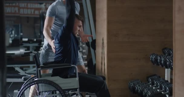 Fauteuil roulant homme soulevant du poids dans la salle de gym — Video