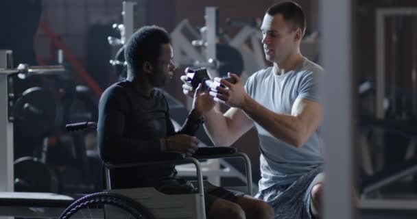 Fauteuil roulant homme soulevant du poids dans la salle de gym — Video