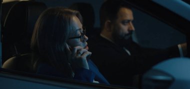 Man driving and woman phoning