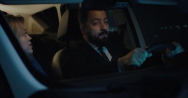 Happy couple traveling in car and chatting