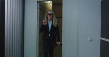 İş kadını ofis koridorunda VR gözlüğü kullanıyor.