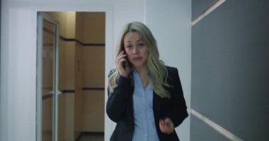 İş kadını ofis koridorundan arıyor.