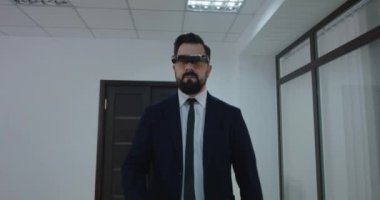 İş adamı ofis koridorunda VR gözlüğü kullanıyor.