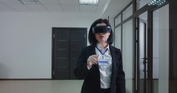 Empresária usando óculos VR no corredor do escritório — Vídeo de Stock