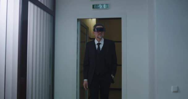 Бизнесмен, использующий очки VR в офисном коридоре — стоковое видео