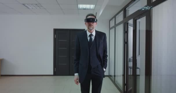 Бизнесмен, использующий очки VR в офисном коридоре — стоковое видео