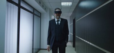 İş adamı ofis koridorunda VR gözlüğü kullanıyor.