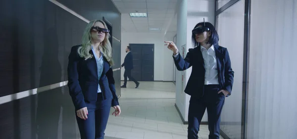 Деловые женщины используют очки VR в офисном коридоре — стоковое фото