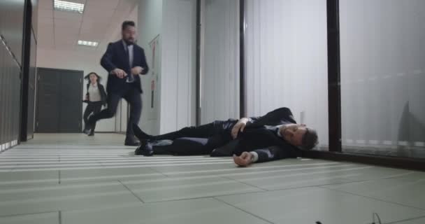 Compañeros corriendo para ayudar al gerente inconsciente — Vídeos de Stock
