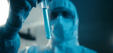 Bilimadamı laboratuvarda numune inceliyor.