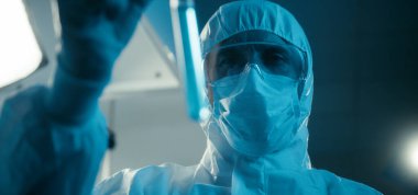 Bilimadamı laboratuvarda numune inceliyor.