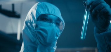 Bilimadamı laboratuvarda numune inceliyor.