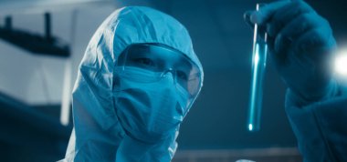 Bilimadamı laboratuvarda numune inceliyor.