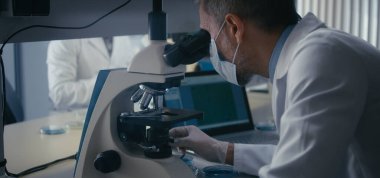Bilimadamı mikroskopta numune inceliyor