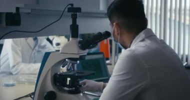 Bilimadamı mikroskopta numune inceliyor