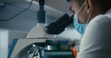 Bilimadamı mikroskopta numune inceliyor