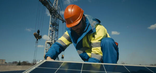 Technician installing solar panel and looking at camera