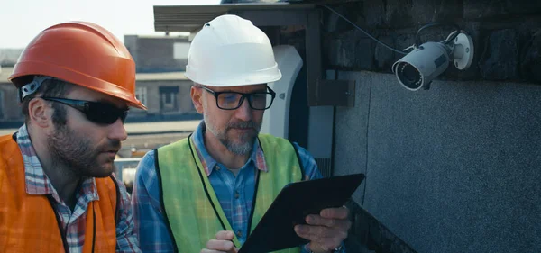 Ingénieur et technicien discutant de caméra de sécurité — Photo