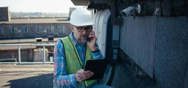 Ingegnere controllo telecamera di sicurezza utilizzando tablet — Foto Stock