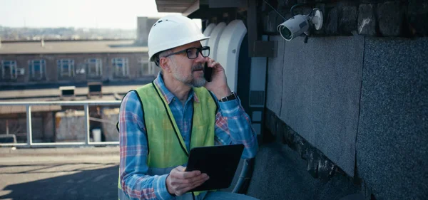 Engenheiro verificando câmera de segurança usando tablet — Fotografia de Stock