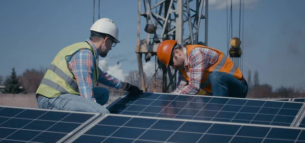 Técnicos instalando painéis solares na luz do sol — Fotografia de Stock