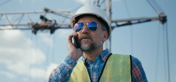 Ingenieur koordiniert am Telefon auf Baustelle — Stockfoto