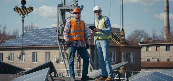 Inżynier i technik omawiający między panelami słonecznymi — Zdjęcie stockowe