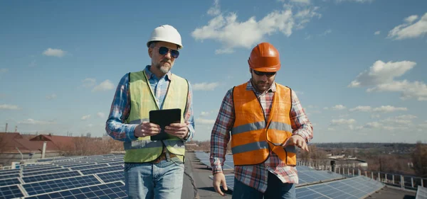 Ingénieur et technicien discutant entre panneaux solaires — Photo