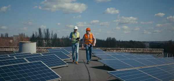 Inżynier i technik omawiający między panelami słonecznymi — Zdjęcie stockowe