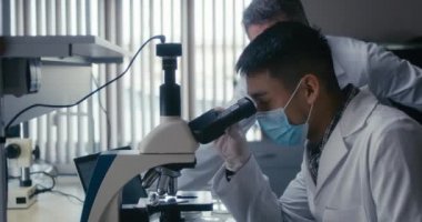 Bilimadamı mikroskopta numune inceliyor