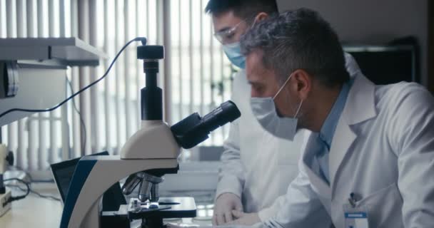 Bilim adamı laboratuvarda kameraya bakıyor. — Stok video