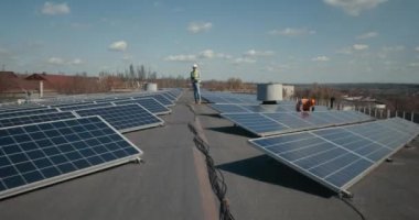 Teknisyenler düz çatıya güneş panelleri kuruyorlar