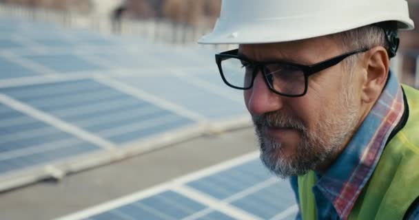 Técnico falando com alguém antes de painéis solares — Vídeo de Stock