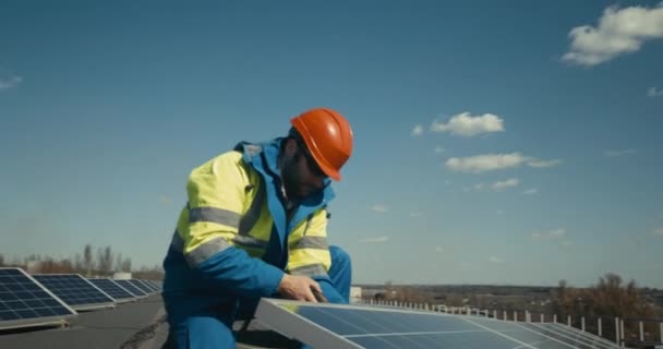 평평 한 지붕에 태양 전 지판을 설치하는 기술자 — 비디오