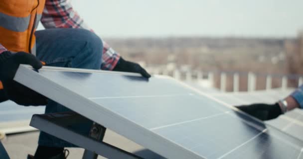 Técnicos instalando paneles solares en soporte metálico — Vídeo de stock