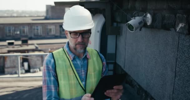 Engenheiro verificando câmera de segurança usando tablet — Vídeo de Stock