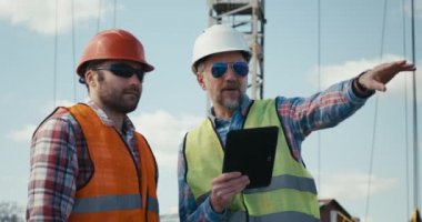Mühendis ve teknisyen tablet kullanarak tartışıyor